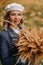 Portrait of a Girl in a jacket and birette with an autumn bouquet in an autumn park