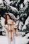 Portrait of a girl with long hair in mittens in a winter forest . Snowy winter