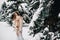 Portrait of a girl with long hair in mittens in a winter forest . Snowy winter