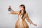 Portrait of a girl in a lush golden rococo dress posing standing with a lamp in her hands isolated on a white background