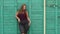 Portrait of a girl model plus size on the background of a green wall.