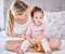 Portrait of girl with mother in bedroom in home, bonding and playing while holding toy. Love, family and caring happy