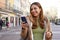 Portrait of girl outdoor messaging with chatting app on smartphone in pedestrian area