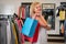 Portrait of a girl with paper bags in the clothing department of a shopping mall, seasonal sale, womens shopping, light