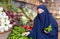 Portrait of girl in paranja buying bell peppers in grocery shop