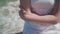 Portrait of a girl on the seashore. Beautiful girl, close-up of hands, hair and a white dress.