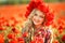 Portrait of a girl on the street with a wreath of poppy flowers on the head