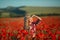 Portrait of a girl on the street with a wreath of poppy flowers on the head