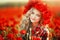 Portrait of a girl on the street with a wreath of poppy flowers on the head