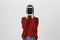 Portrait of girl in trendy red sweater covering her face with a tablet standing near white wall. Technology and gadget
