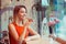 Portrait of a girl using the voice recognition of the phone sitting in a trendy cosy coffee shop cafe in Manhattan New York