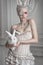 Portrait of a girl in a whight costume holding a white bunny