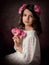 Portrait of a girl in a white dress, she holds branches of pink orchid flowers in her hands.