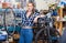 Portrait of girl who is working and replacing wheels with another one in workshop.