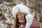 Portrait of a girl in winter clothes on a walk in the park. Snowball in hand. Close-up shot