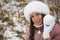 Portrait of a girl in winter clothes on a walk in the park. Snowball in hand. Close-up shot