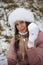 Portrait of a girl in winter clothes on a walk in the park. Snowball in hand. Close-up shot