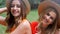 Portrait of girls in hats sitting outside in summer