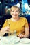 Portrait of glad retiree woman sitting in cafe