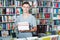 Portrait of glad teenager boy with book pile