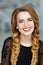 Portrait of a glamorous beautiful girl with bright makeup in black dress and braids, laughing, studio, close-up