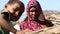 Portrait of gloomy Indian woman in traditional clothing, with child in front.