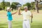 Portrait of golfer couple giving high five