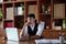 A portrait of a good-looking and discreet Asian man sitting at his desk with a thoughtful look on his computer