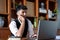 A portrait of a good-looking and discreet Asian man sitting at his desk with a thoughtful look on his computer