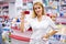 Portrait of good-looking drugstore worker holding props card of pharmacy in hands