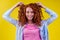 Portrait of good-looking foxy redhead female with afro curly shiny hair and natural make-up smiling. dyed hair concept