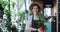 Portrait of good-looking girl holding houseplant standing in flower shop