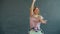 Portrait of good-looking young lady dancing in modern studio on grey background