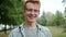 Portrait of good-looking young man with red hair smiling in park in summer