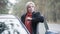 Portrait of gorgeous blond woman standing next to open car on suburban road. Positive Caucasian young lady enjoying road