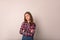 Portrait of a gorgeous female in fashionable plaid shirt standing with crossed arms  in studio