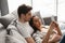 Portrait of gorgeous people man and woman lying on sofa at home, and using mobile phone