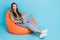 Portrait of gorgeous positive girl with straight hair dressed striped t-shirt typing code on laptop isolated on blue