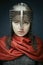 Portrait of gorgeous young woman in  knight armour and steel chainmaille on dark background.