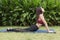 Portrait of gorgeous young woman practicing yoga in garden,Asian women meditating with yoga on a mat,Health fitness concept