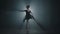 Portrait graceful professional ballerina dancing in black dress in the studio in spotlight on a black background
