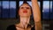 Portrait of graceful woman looking at camera and dancing in dark loft studio