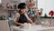 Portrait of grandchild wearing apron rolling homemade dough using rooling pin