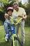 Portrait of grandfather assisting grandson while riding bicycle