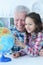 Portrait of grandfather and granddaughter exploring world globe