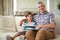 Portrait of grandfather with her grandson holding book on sofa