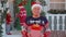 Portrait of grandfather man presenting gift box smiling near decorated Christmas house with family