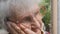 Portrait of grandmother with emotions and feelings. Old woman looking with sad expression outdoor. Grandma keeping hand