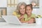 Portrait of grandmother and granddaughter using laptop