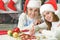 Portrait of grandmother with teen girl in Santa hats preparing for Christmas at home